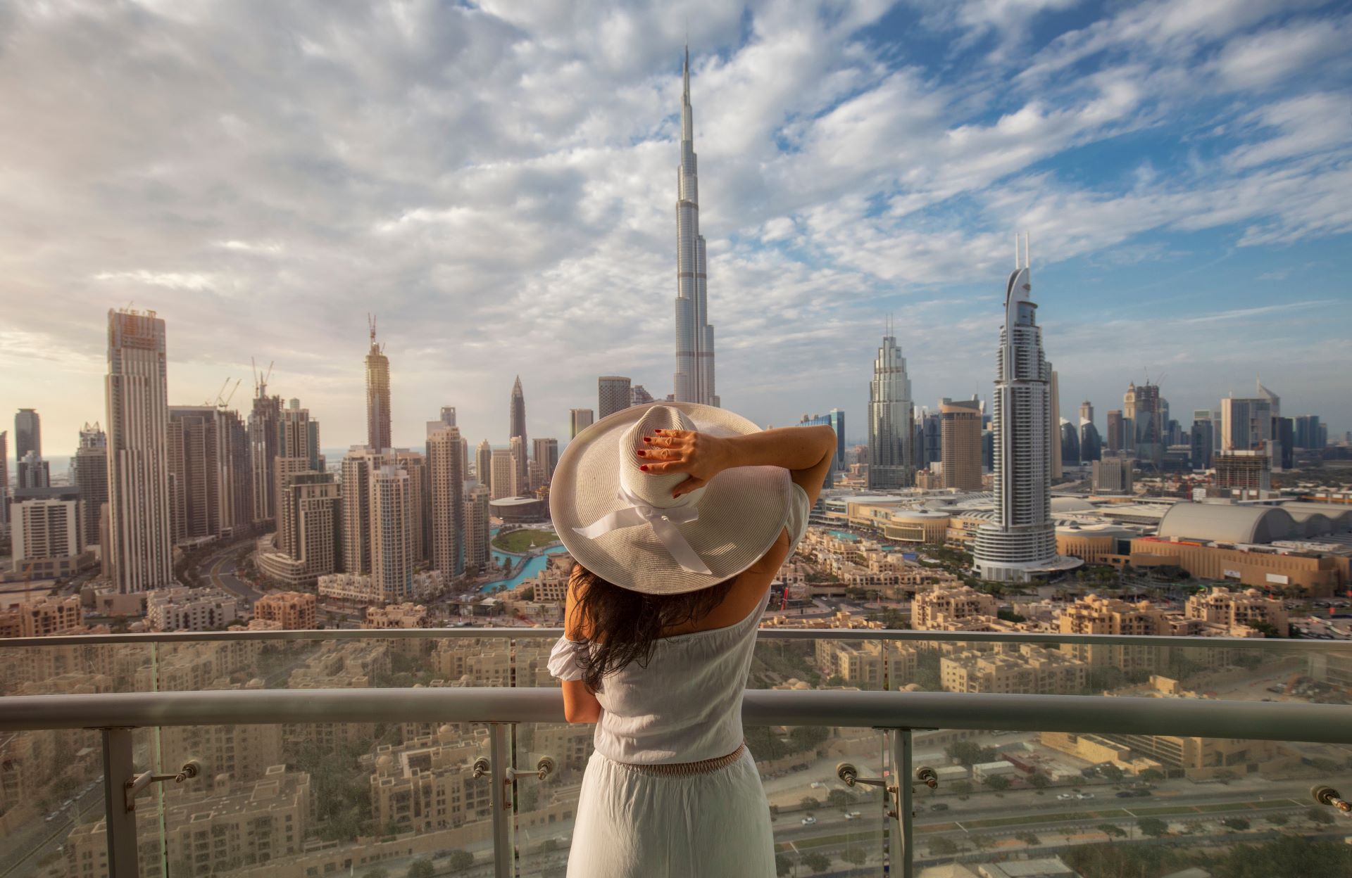 Frau auf Balkon mit Blick auf Dubais Skyline